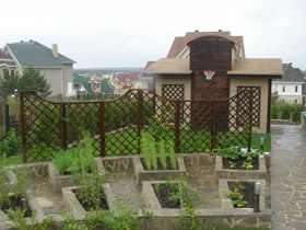 Декоративный огород отгорожен от спортивной площадки шпалерами, увитыми диким виноградом