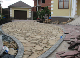 Мощение обширной въездной зоны перед гаражом и парадным крыльцом дома во время работ по облицовке железобетонного основания натуральным камнем (плитняком). Рисунок подчёркивает направление движения.
