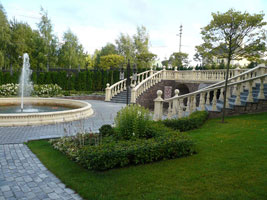 Площадка с фонтаном окантована живой изгородью и украшена партерными цветниками